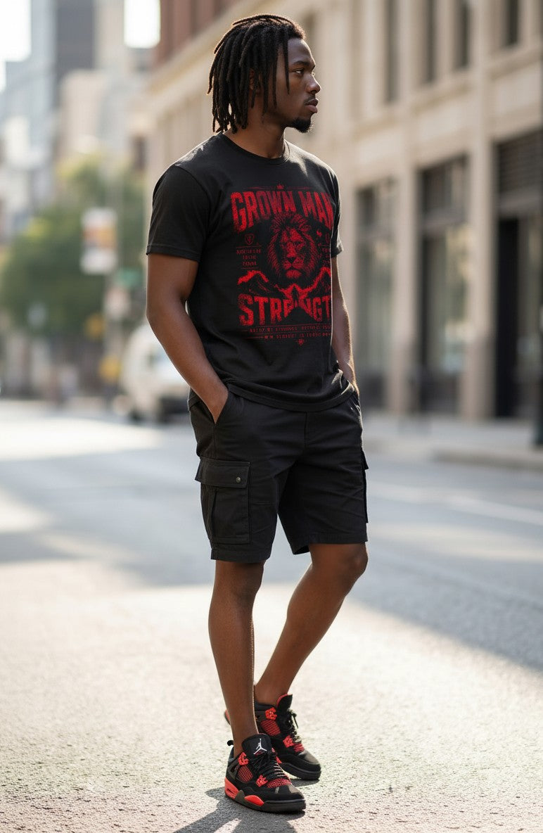 Man wearing a black t-shirt with red text and cargo shorts on a city street.