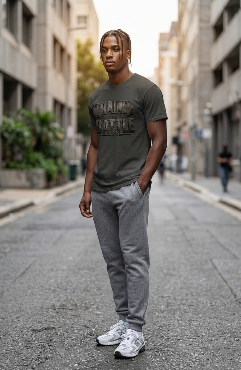 Man wearing a green t-shirt with text and gray pants standing on a city street.