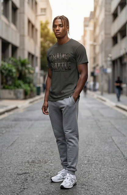 Man wearing a green t-shirt with text and gray pants standing on a city street.