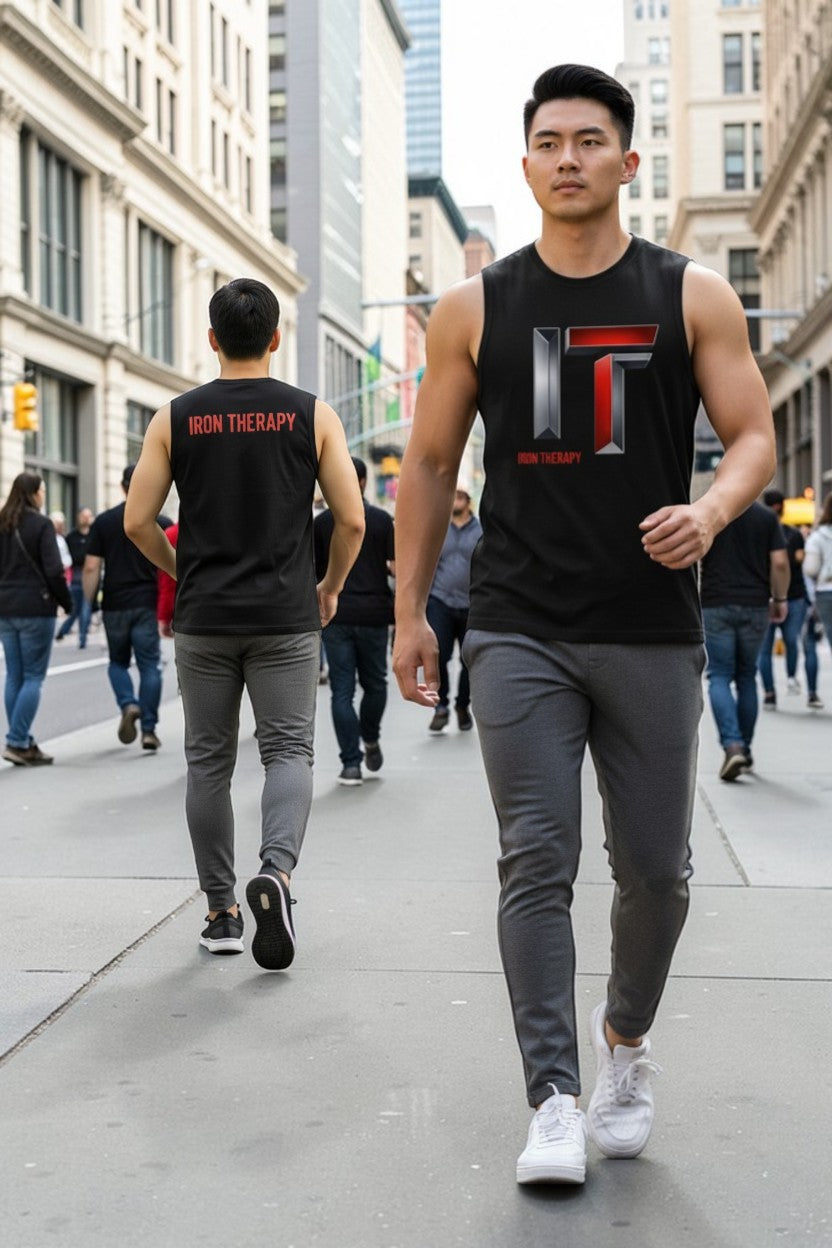 Two men walking on a city street wearing black tank tops with a logo.