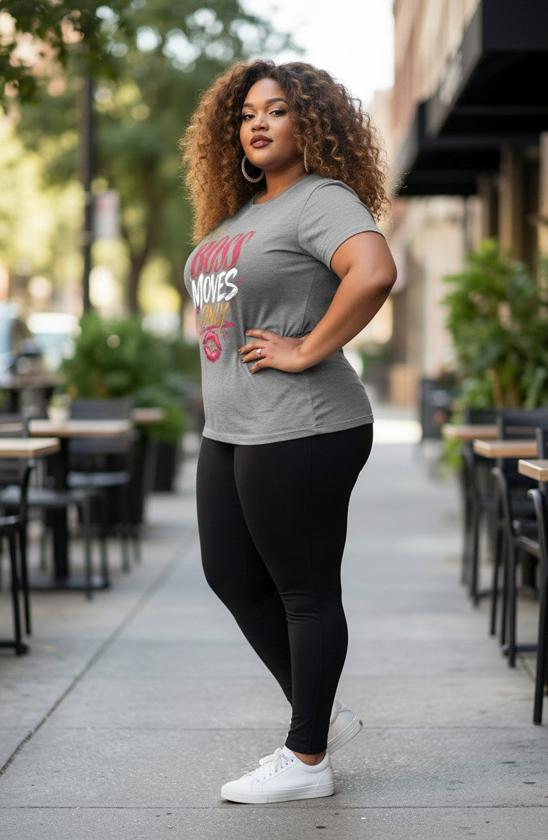 Woman wearing a gray t-shirt with text and black leggings standing on a sidewalk.