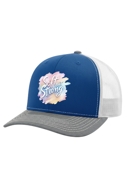 Blue and white cap with 'Soft but Strong' text and floral design on a white background