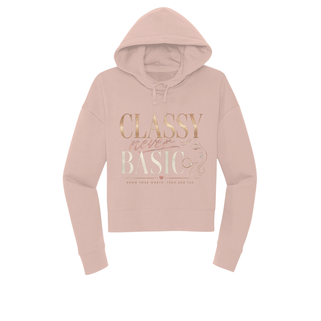 A dusty pink cropped hoodie with a front graphic that reads 'CLASSY never BASIC' in metallic rose gold and white lettering, displayed on a clean white background.