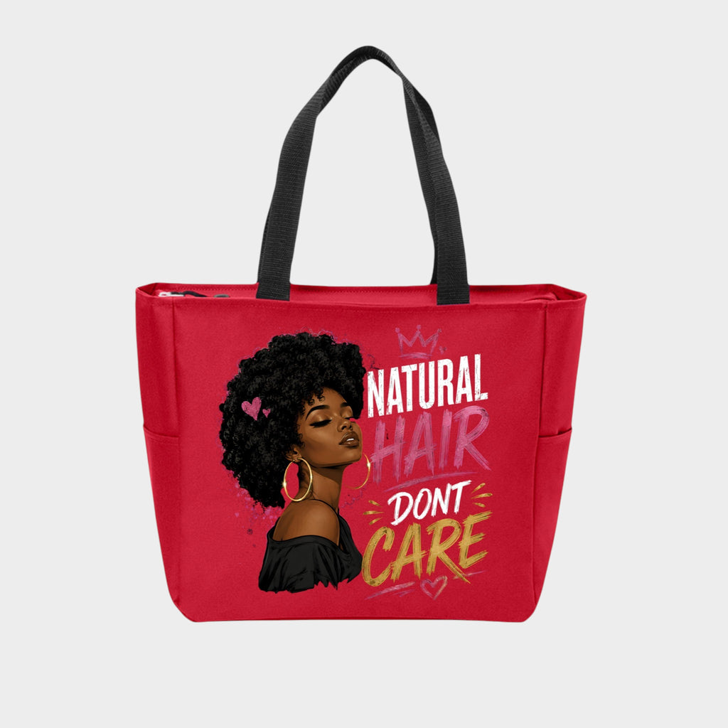 A red tote bag with black handles, featuring a graphic of a Black woman with an afro and the text 'NATURAL HAIR DON'T CARE' in white, pink, and yellow lettering, set against a light gray background.