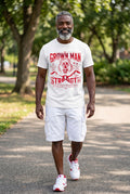 Man wearing a 'Grown Man Strength' t-shirt in a park