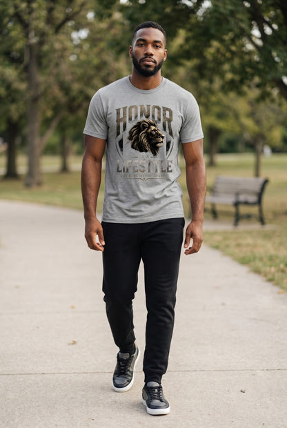 Man wearing a gray t-shirt with a lion graphic and text, walking on a path in a park.