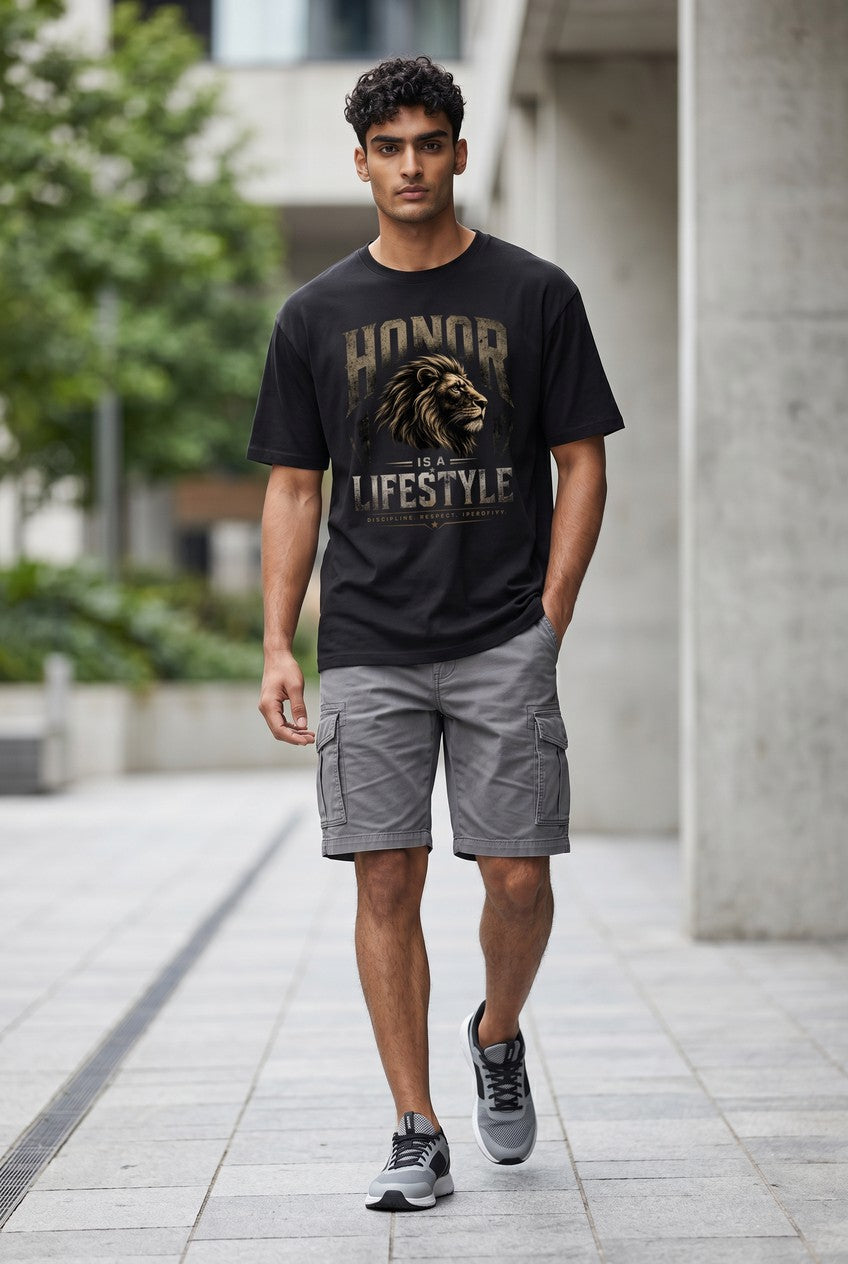 Man wearing a black t-shirt with a lion graphic and text, standing on a sidewalk.