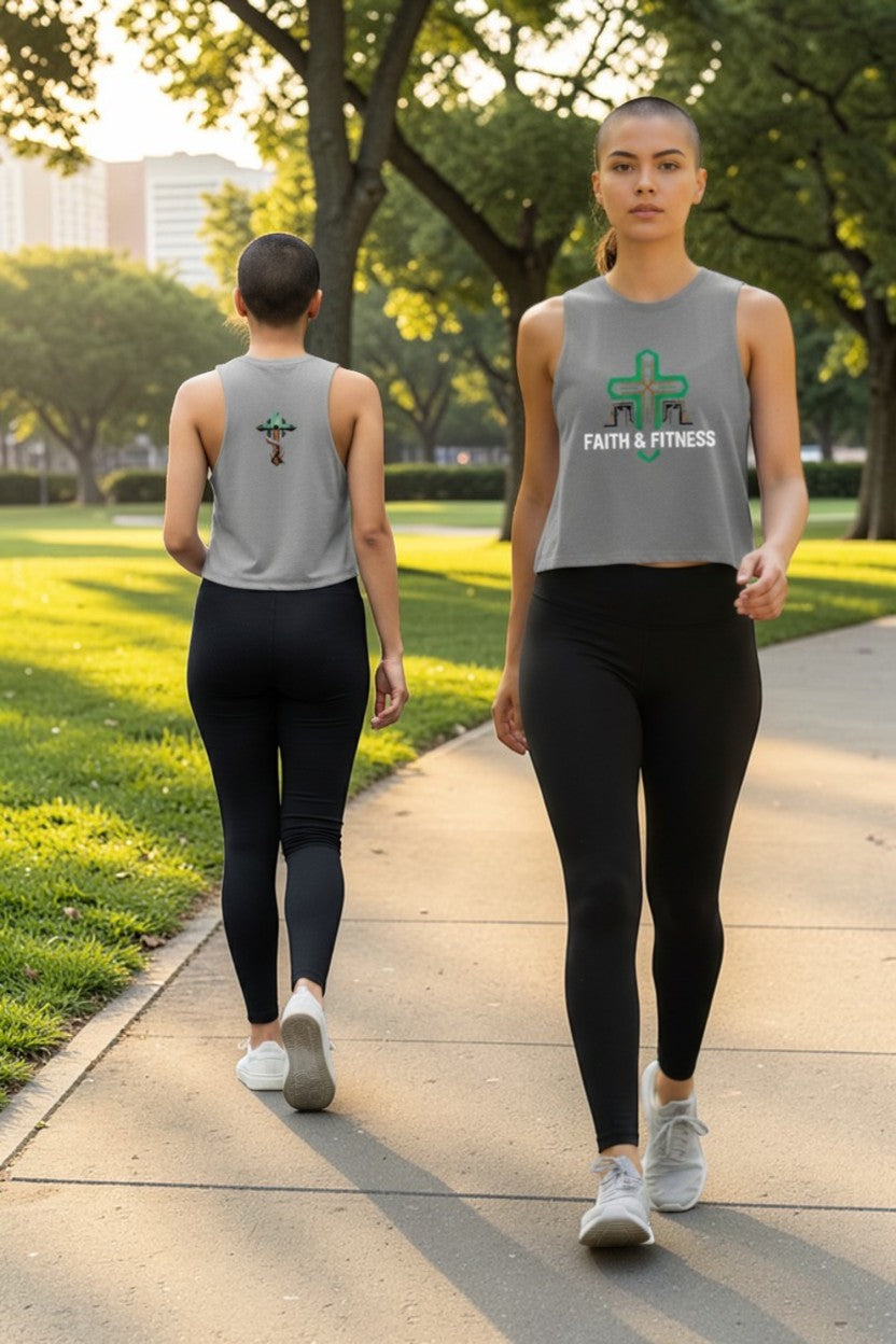 Two people walking on a path in a park wearing matching gray tank tops with logos.