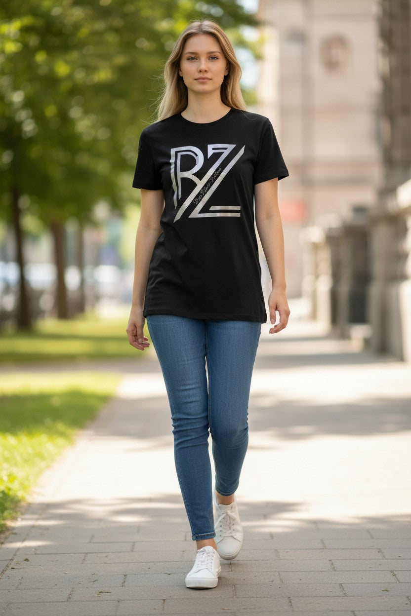 Woman wearing a black t-shirt with a logo and blue jeans walking on a sidewalk.