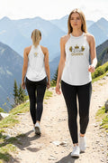 Two women walking on a trail with mountains in the background, wearing white tank tops with 'Gym Queen' text.