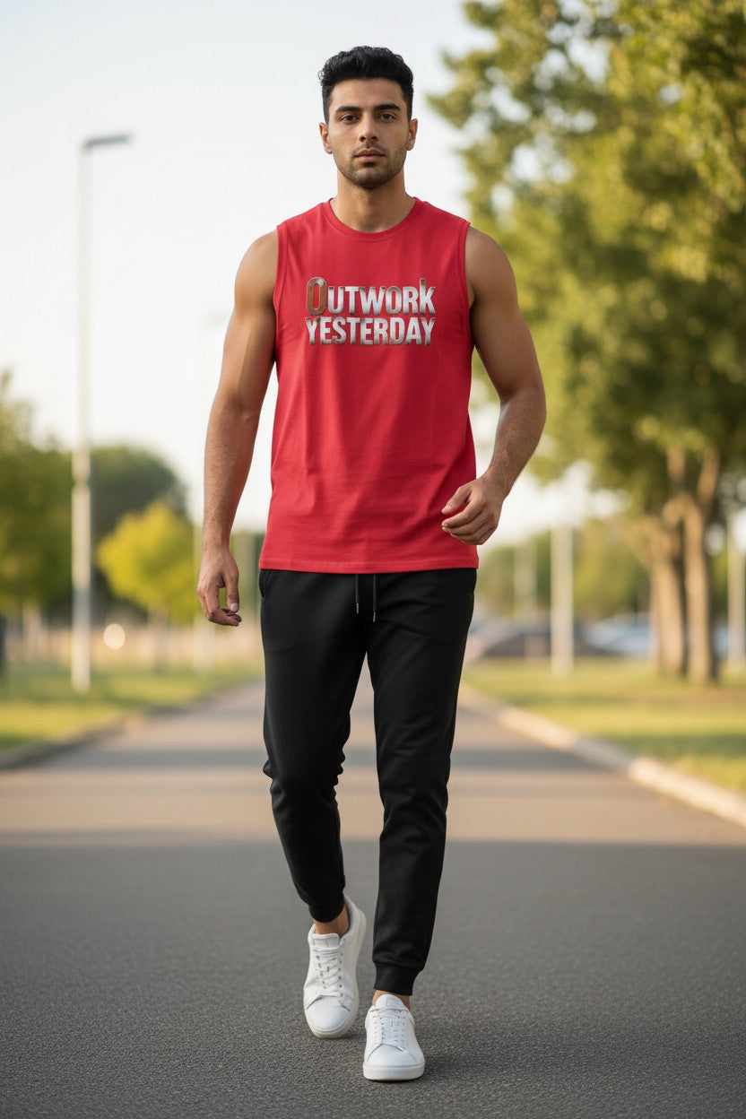 Man walking outdoors wearing a red tank top with text and black pants.