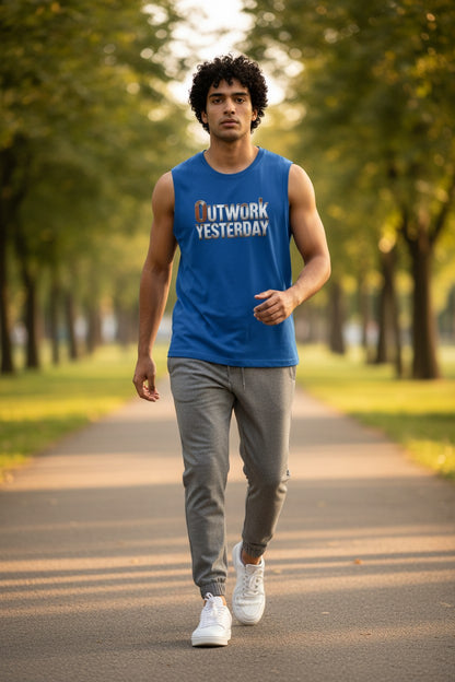 Man walking on a path in a park wearing a blue sleeveless shirt with text and gray pants.