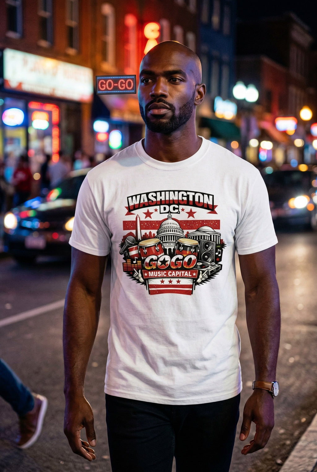Man wearing a 'Washington DC Go-Go Music Capital' t-shirt on a city street at night.