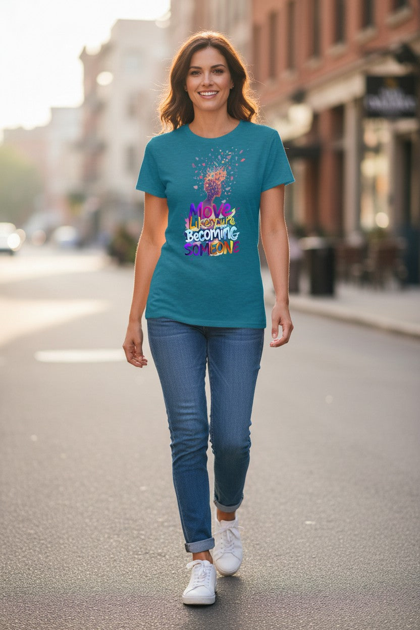 Woman walking on a street wearing a teal t-shirt with colorful text and graphics.