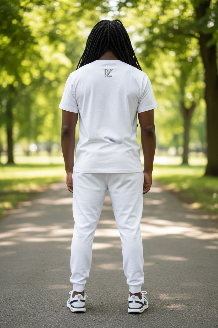 Person wearing a white t-shirt and pants walking on a path in a park.