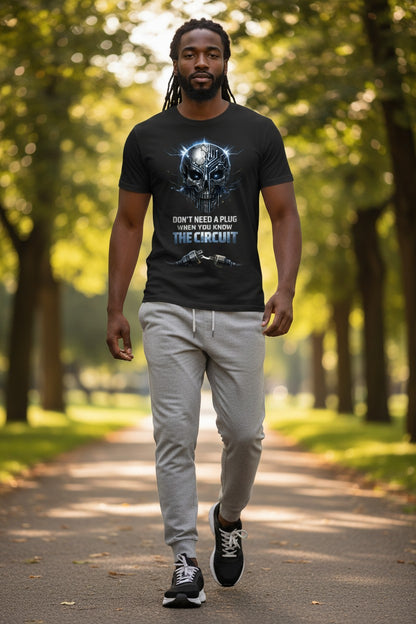 Man walking on a path in a park wearing a black t-shirt with graphic design and text.