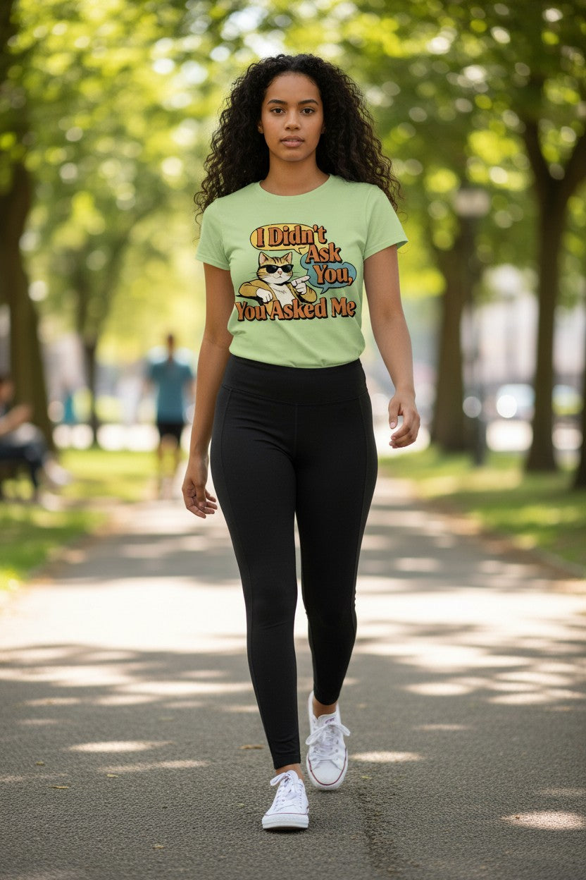 Woman walking outdoors wearing a light green t-shirt with a graphic design.
