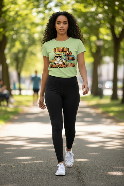 Woman walking outdoors wearing a light green t-shirt with a graphic design.