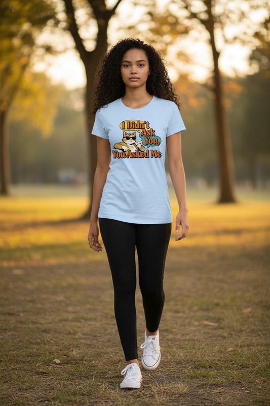 Woman wearing a light blue t-shirt with text and graphics in a park setting