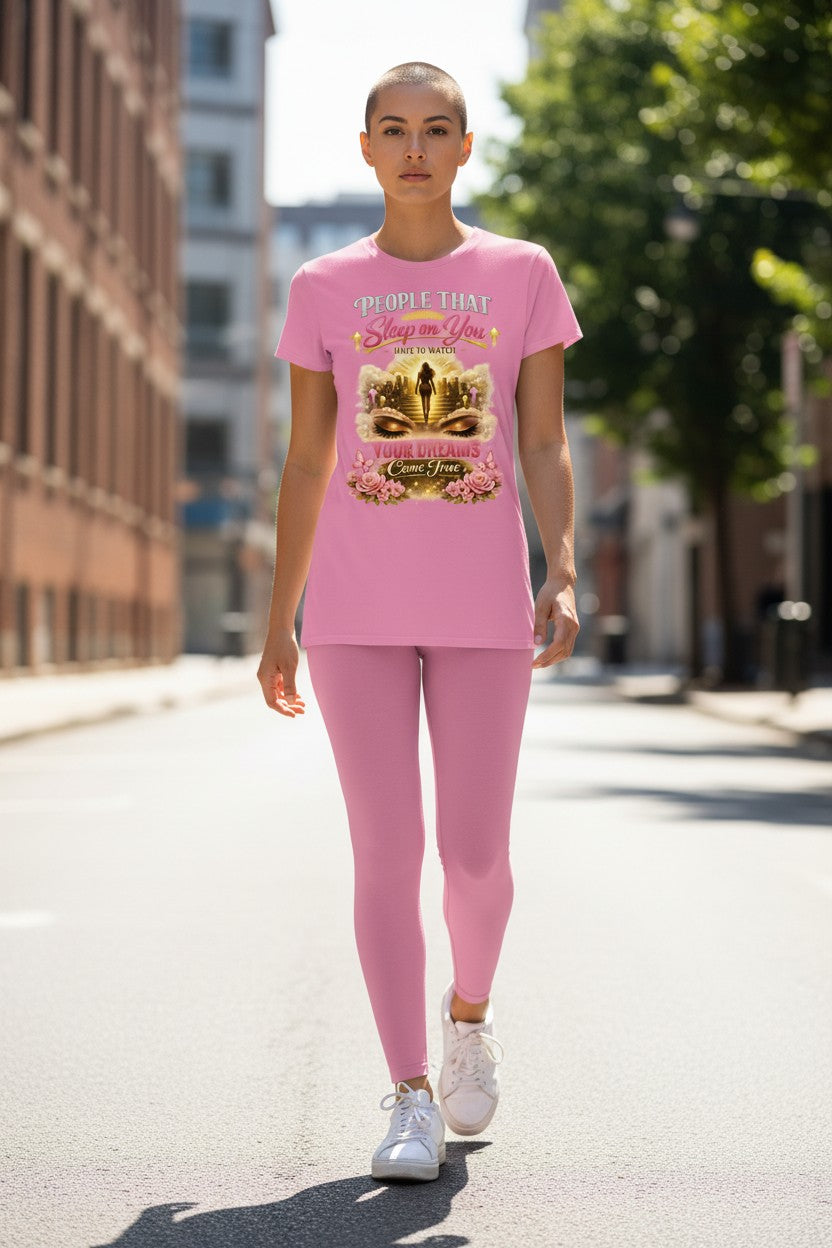 Person wearing a pink outfit with a graphic design on a city street
