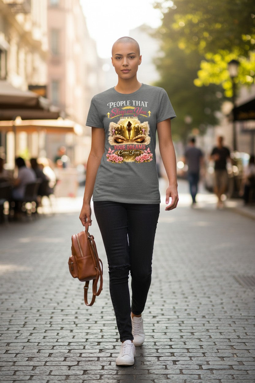 Person wearing a gray t-shirt with a colorful graphic design on a city street.