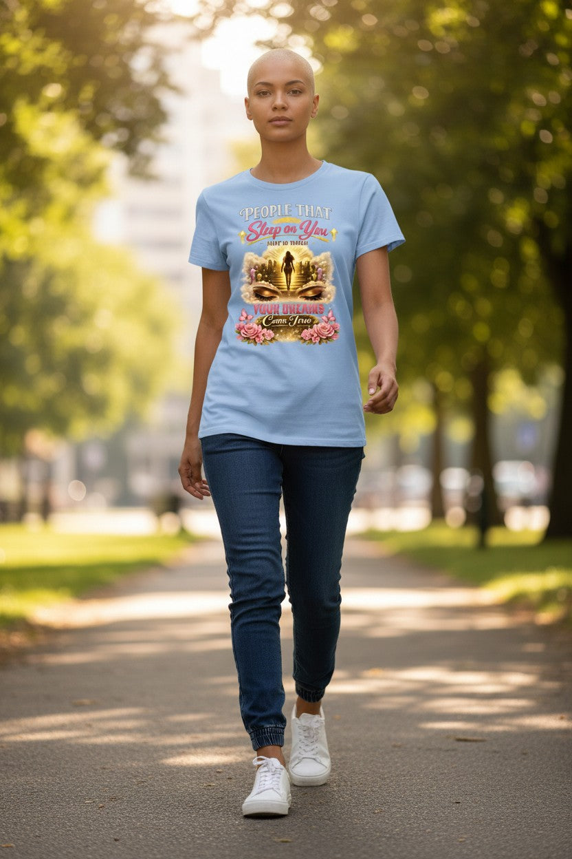 Person walking outdoors wearing a light blue t-shirt with a graphic design.