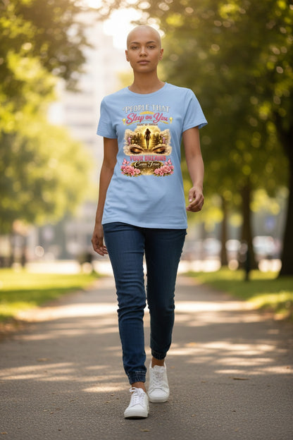 Person walking outdoors wearing a light blue t-shirt with a graphic design.