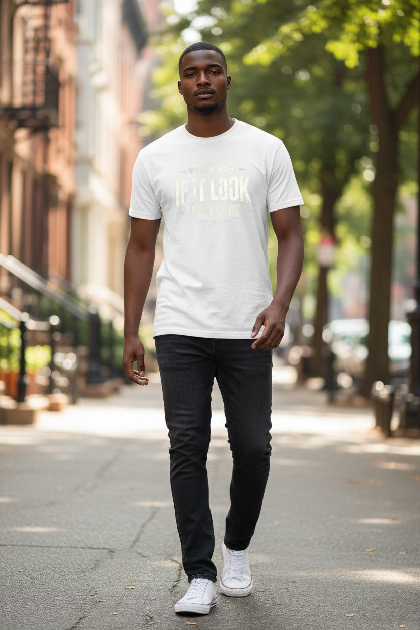 Man walking on a city street wearing a white t-shirt with text and dark pants.