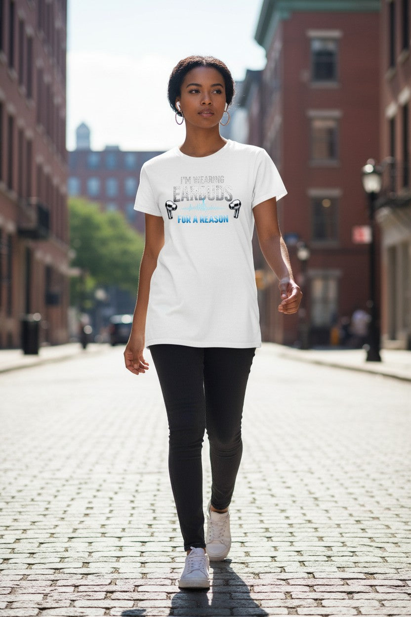 Person wearing a white t-shirt with text and graphics on a city street.