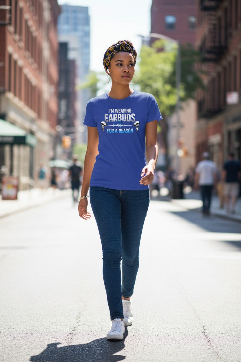 Woman walking on a city street wearing a blue t-shirt with text.