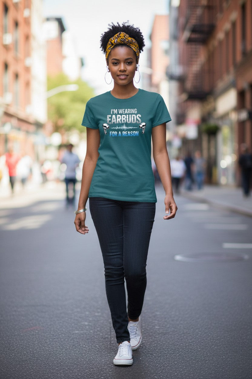 Woman walking on a city street wearing a teal t-shirt with text.
