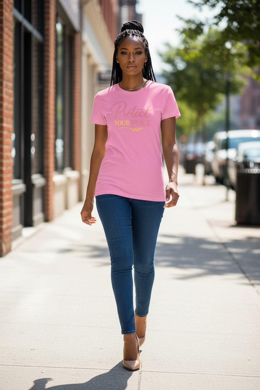 Woman walking on a sidewalk wearing a pink t-shirt and blue jeans.