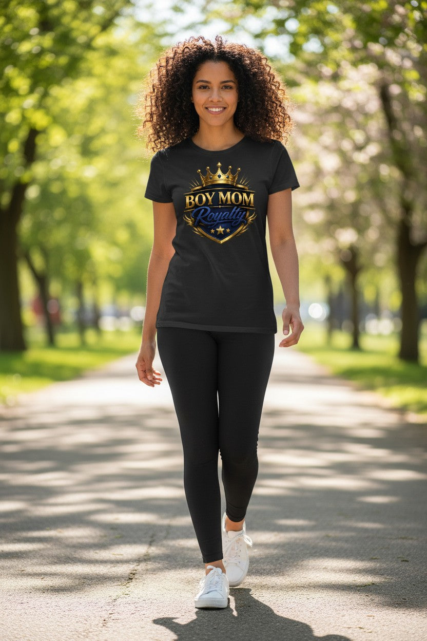 Woman wearing a black t-shirt with 'Boy Mom Royalty' design in a park.