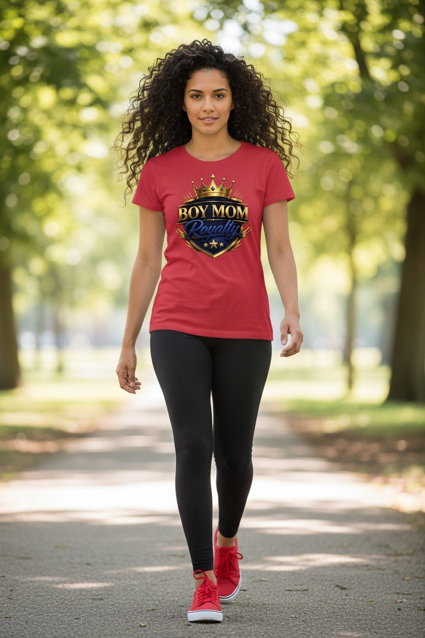 Woman wearing a red t-shirt with a logo and text, walking outdoors on a path with trees.