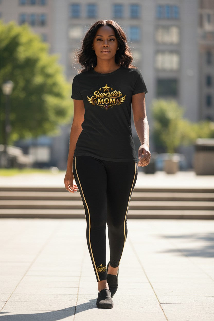 Woman wearing a black t-shirt with 'Superstar Mom' text and black leggings with gold accents, standing outdoors.