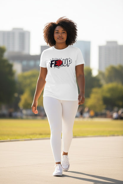 Woman wearing a white t-shirt with a logo and text, walking outdoors with trees and buildings in the background.