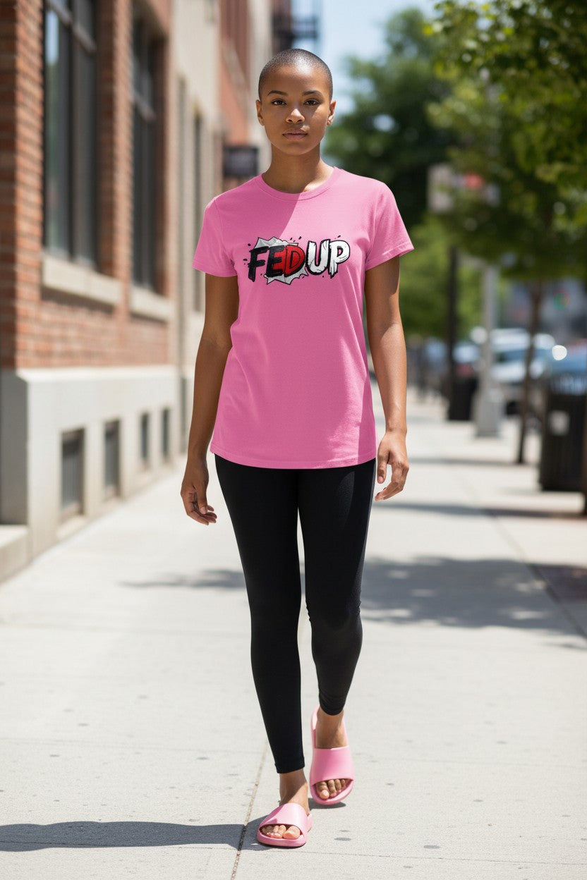 Person wearing a pink 'FEED UP' t-shirt on a city street.