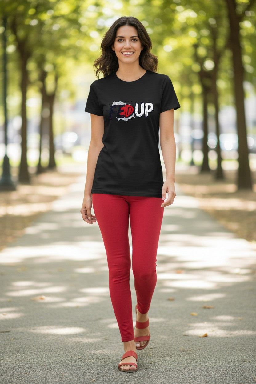 Woman wearing a black t-shirt with '3UP' logo and red pants walking on a tree-lined path.
