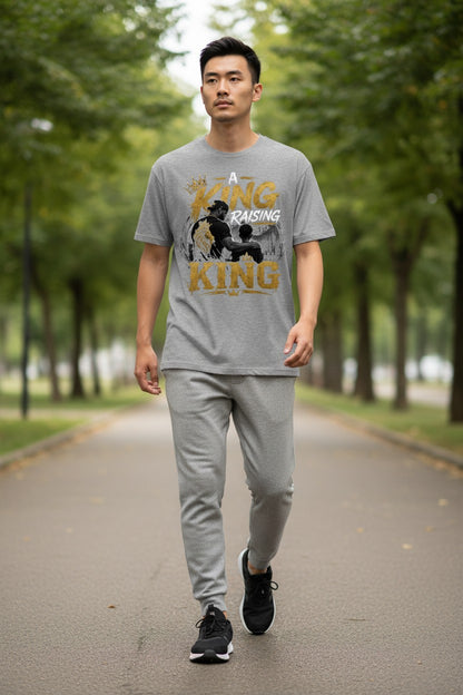 Man walking on a path in a park wearing a gray t-shirt with a graphic design.