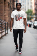 Man walking on a city street wearing a white t-shirt with 'FED UP' graphic design.