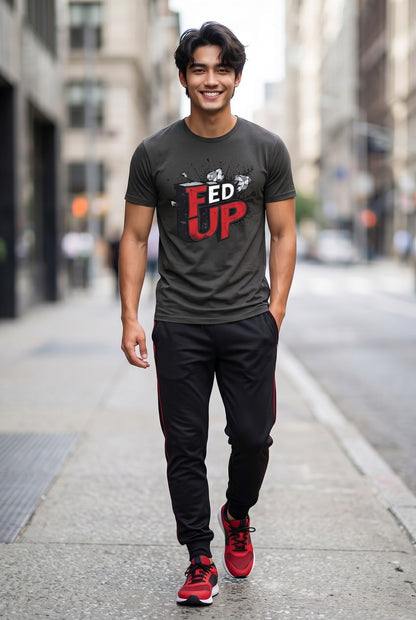Man wearing a gray t-shirt with 'FED UP' text, black pants, and red shoes on a city street.