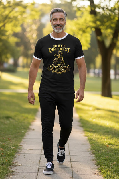 Man walking on a path in a park wearing a black t-shirt with text and graphics.