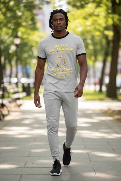 Man walking outdoors in a park wearing a gray t-shirt with yellow text and graphics.