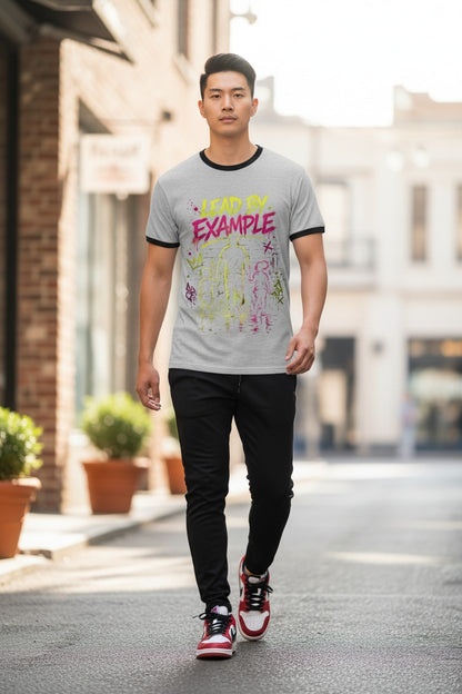Man wearing a gray t-shirt with colorful text walking on a street.
