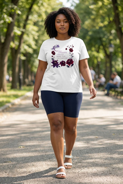 Woman walking outdoors wearing a white t-shirt with floral design and dark blue shorts.