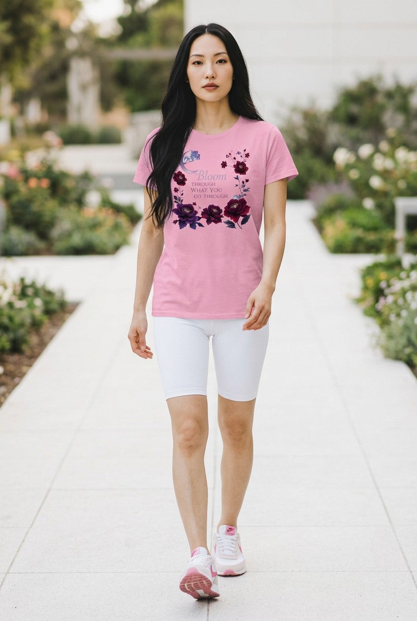 Woman wearing a pink t-shirt with floral design and white shorts walking outdoors.