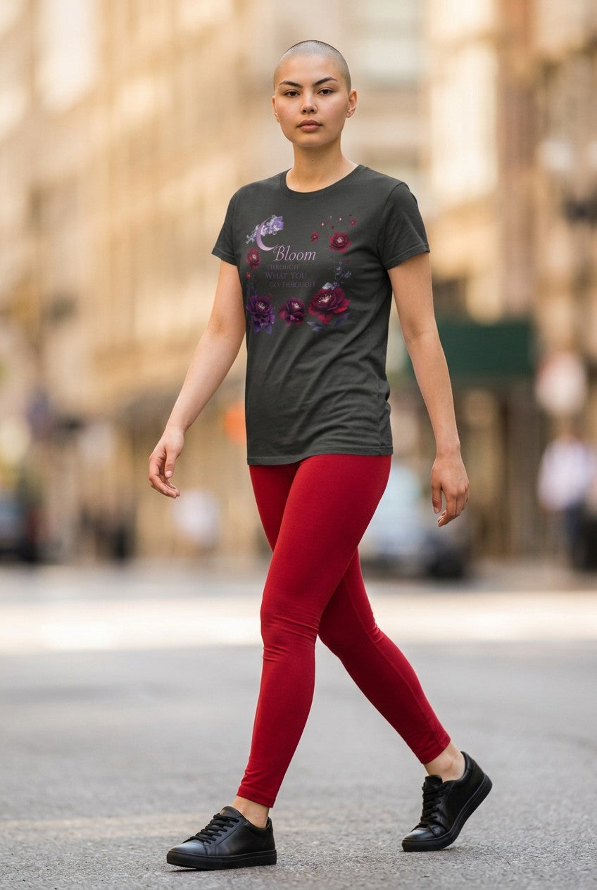 Person wearing a dark t-shirt with floral designs and red pants walking on a street.