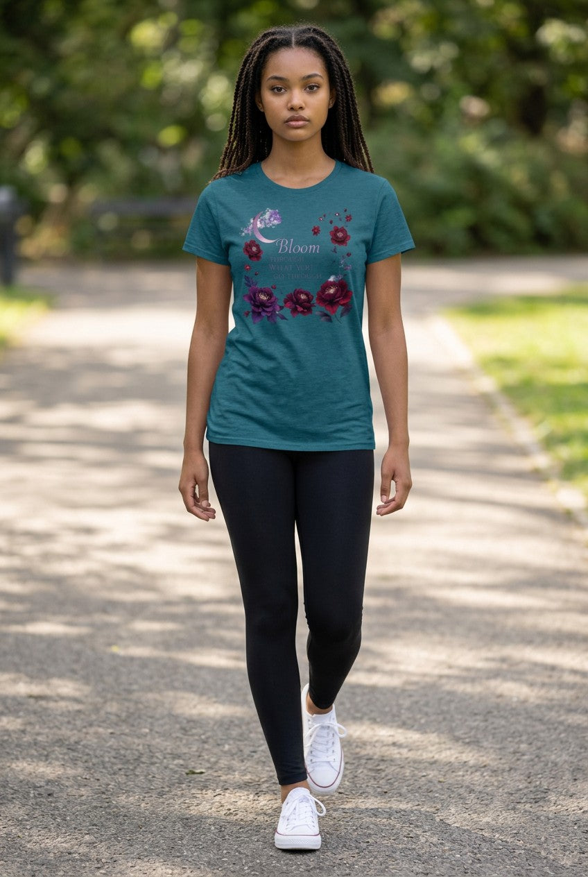 Woman wearing a teal t-shirt with floral design outdoors