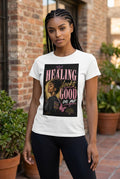 Woman wearing a white t-shirt with a graphic design and text outdoors.