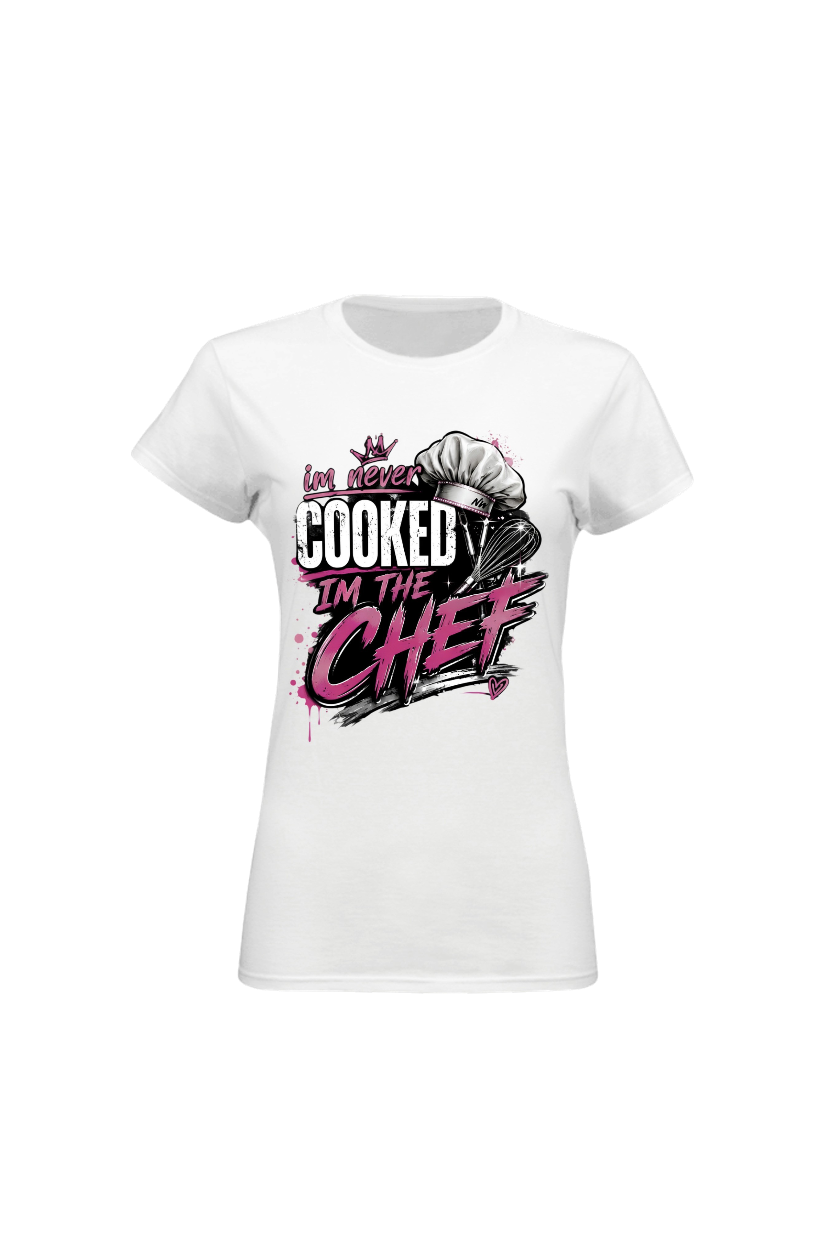 A white short-sleeve crewneck t-shirt with a graphic print on the front. The graphic features a chef's hat and the text 'Las never COOKED I'M THE CHEF' in black and pink lettering.